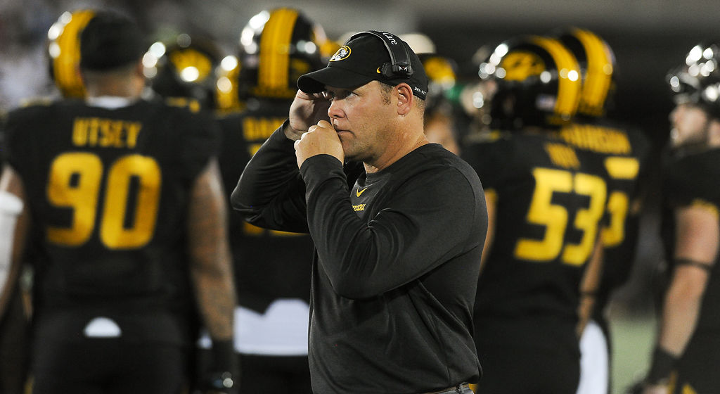Barry Odom communicates with his coaching staff
